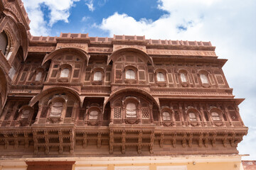Obraz premium Look up at the red and yellow castle standing majestically on the hill. Mehrangarh Fort is in Jodhpur, Rajasthan, India. UNESCO World Heritage Site.