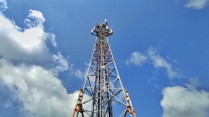 Technology background of transmitter tower in cloudy sky during daylight