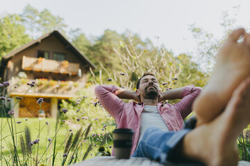 Relaxed man sitting in the garden with feet on table. Father having moment to himself while his kids are in school.
