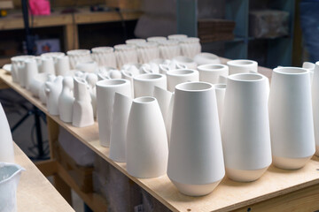 Finished plaster products: vases, figurines, bowls. Making and casting decorative dishes and vases from plaster for home decoration in the workshop. 