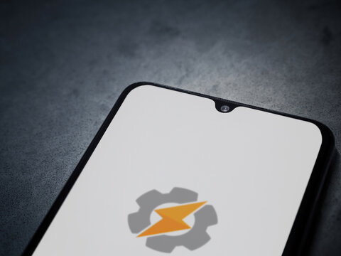 Lod, Israel - July 16,2023: Tasker app launch screen on smartphone on dark marble stone background. Top view flat lay with copy space.