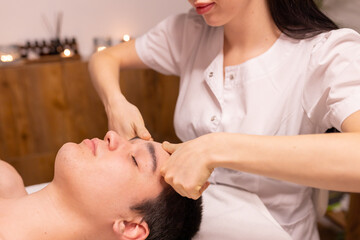 Obraz na płótnie Canvas Young man receiving massage at spa salon