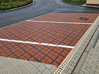 Fototapeta premium drainage paving with infiltration holes between concrete blocks in the parking lot of the department store, lines, white, road marking