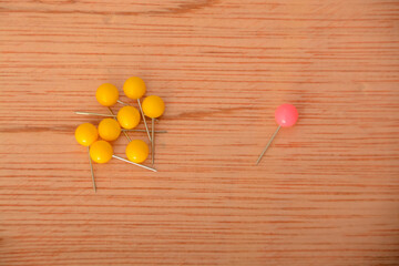 Among a group of yellow clothespins, the solitary pink one appeared to be abandoned and exceptional.