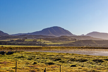 Small dam on farm in early morning light with mountains in background near Riversdale in the Western Cape, South Africa