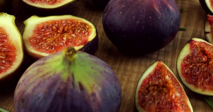 Figs and fig slices on a wooden board.