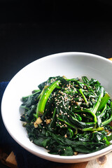 Food concept Spot focus Korean Spinach Salad on black background with copy space