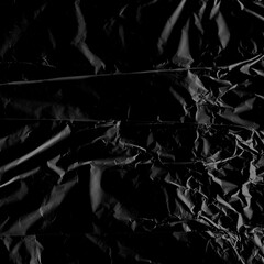 Wrinkled plastic wrap texture on a black background wallpaper. Royalty high-quality free stock photo image of realistic plastic wrap for overlay, copy space and photo effect. Wrinkled plastic surface