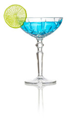 Blue cocktail in a fancy glass garnished with slice of lime isolated on white reflective surface.