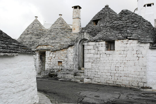 A charming lane meanders through Alberobello's trulli, showcasing these iconic conical-roofed dwellings, a UNESCO World Heritage marvel.