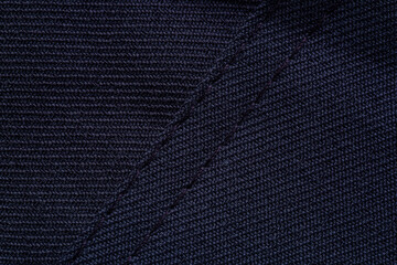Macro black fabric detail,Black fabric and seam details,Black stitching on black cloth. Black work clothes with black stitching.