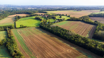 Obraz premium Plowed farmland. Aerial view of fields some showing track marks while others are green and untouched. 