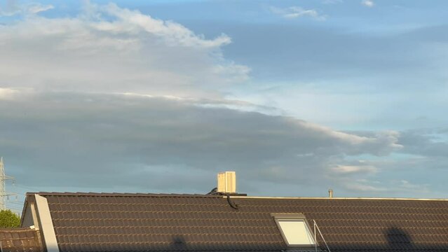 Nachger&uuml;stete Klimaanlage auf dem Dach eines Mehrfamilienhaus w&auml;hrend einem sonnigen Sonnenuntergang im Zeitraffer