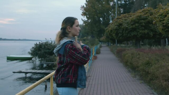 Female tapping her shoulders outdoors near water. Crossing hands. Butterfly hug. EMDR therapy technique.