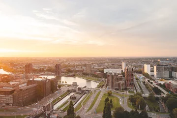 Photo sur Plexiglas Pont Érasme Sunset over Rotterdam city centre and its surrounding park. Sunset in one of the most modern cities in the Netherlands