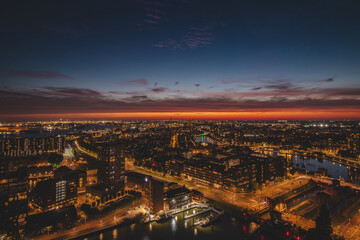 Aerial view of nightlife in the modern city of Rotterdam in the Netherlands. Red glow from the...