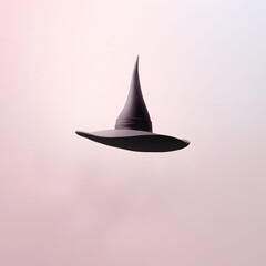 Fototapeta premium Witch hat floating in pastel pink space, minimalistic Halloween costume party concept.