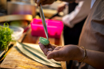 Close up of a sushi chef cutting avocado