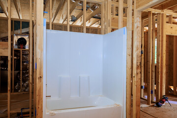 Acrylic bathtub installation with plumbing work in new house bathroom remodel