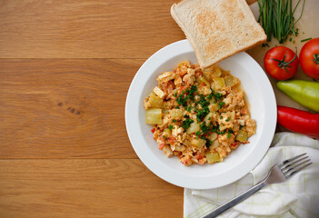 Vegetable dish called lecho containing peppers, tomatoes, onion, eggs and tofu served on white...