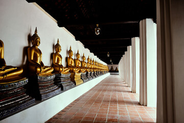 Buddhist statues line a temple pavilion in Thailand