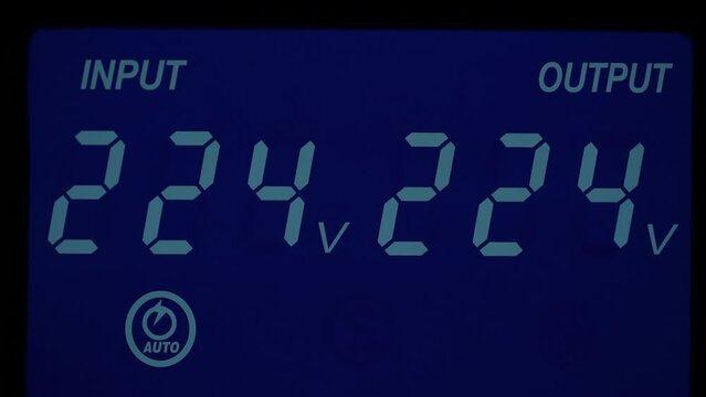 Close up of blue digital display on uninterruptible power supply with automatic voltage stabilizer