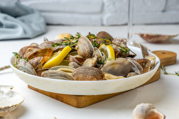 Vongole clams with lemon and herbs in a white plate