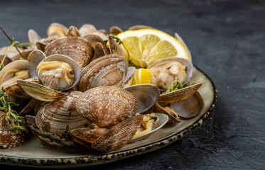 Vongole clams with lemon and herbs, seafood dish, close-up.