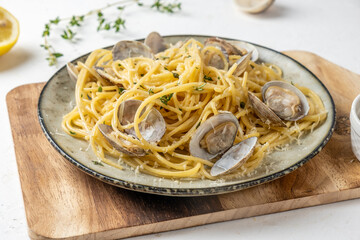 Delicious pasta with seafood, vongole and parmesan, close-up, light background.