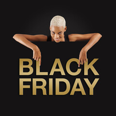 Black Friday shopping. Smiling black woman pointing at a Black Friday golden text on advertising banner commercial sign. Store and mall advertising Billboard guiding shoppers to deals