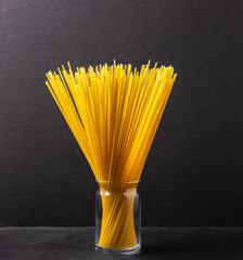 Spaghetti in a glass on a dark background close-up.