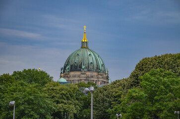 the green dome of the Berlin Cathedral with a golden cross on it