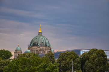 the green dome of the Berlin Cathedral with a golden cross on it - obrazy, fototapety, plakaty