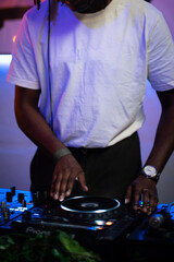 African-American Dj playing on a modern turntable