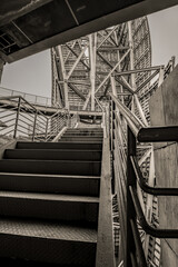 A contrasting shot of a metal structure and a staircase leading up to it, showing strong angles of...