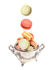 Colored cookies macaroons close-up in a beautiful metal container, moving falling  macaroons on isolated white background