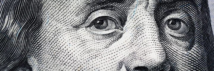 Fotobehang Benjamin Franklin's eyes from a hundred-dollar bill. The eyes of Benjamin Franklin on the hundred dollar banknote, backgrounds, close-up. 100 dollar bill with only eyes of Benjamin Franklin. © Oleksandr