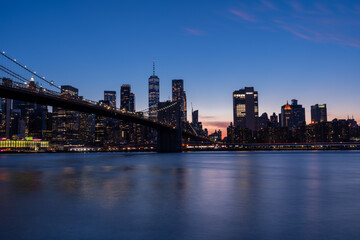 Photograph of Brooklyn Bridge, early evening, bluish light.