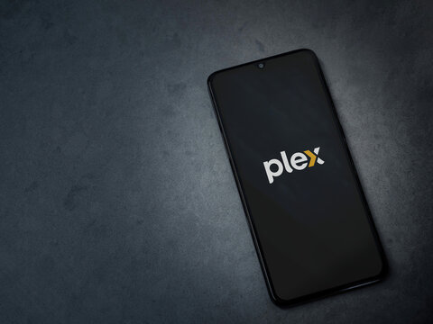 Lod, Israel - July 16,2023: Plex app launch screen on smartphone on dark marble stone background. Top view flat lay with copy space.