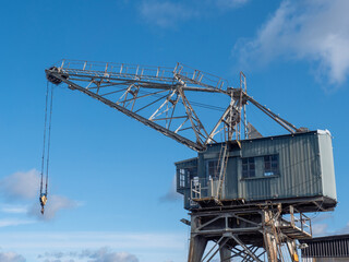 Fototapeta na wymiar Old nostalgic port wooden crane against the blue sky