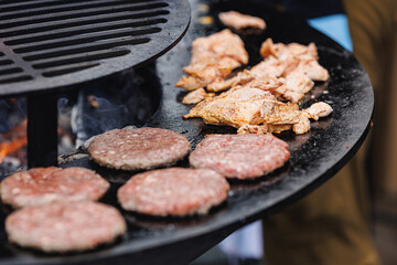 Cook grills steaks and pork ribs open fire. Turns meat over with tongs. Concept Street food