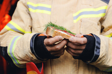 Food of working industry professions, snack of bread, cheese and sausage in hands of fireman