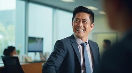 Fototapeta premium Portrait of attractive confident businessman looking at camera in the office. CEO manager photo in the office with a blurred background