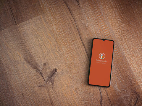 Lod, Israel - July 16,2023: DuckDuckGo Private Browser app launch screen on smartphone on wooden background. Top view flat lay with copy space.