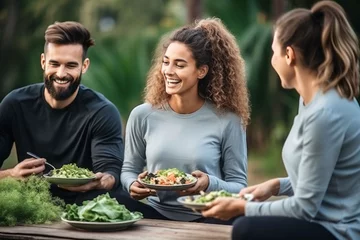 Poster Im Rahmen group diversity young people eating healthy salad after exercising in the park in tracksuit in daytime © A Denny Syahputra