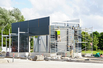 Steel framework of a new unfinished car wash building with unfinished sandwich panels wall