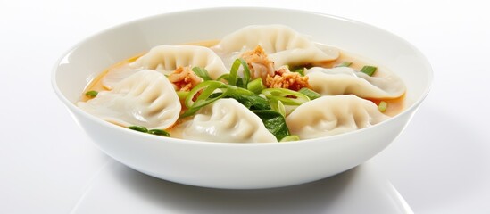 Korean soup with dumplings and rice cakes photographed on a marble table