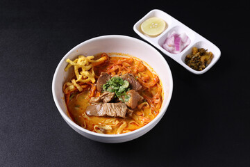 Khao Soi Thai Curry soup isolated in black background