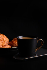 Hot latte coffee with Croissant coffee break isolated in black background