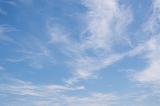 Unusual white striped wavy clouds in a bright blue sky. Heavenly background for your photos. Perfect Sky photo